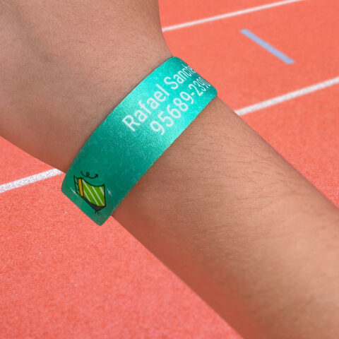 criança usando pulseira de identificação personalizada em um parque